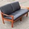 mid-century Teak sofa in profile with black leather cushions