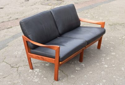 mid-century Teak sofa in profile with black leather cushions